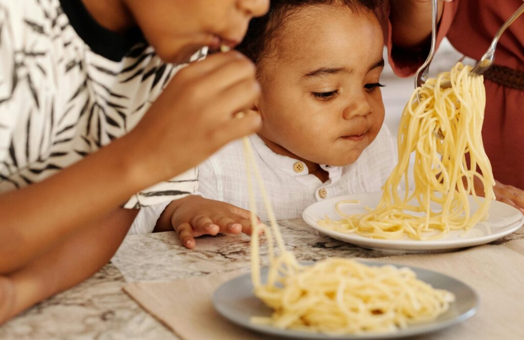 A Young Boys Eating Pasta Together